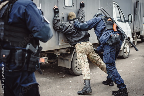 Obraz na plátně Two police officers with machine guns apprehend the perpetrator