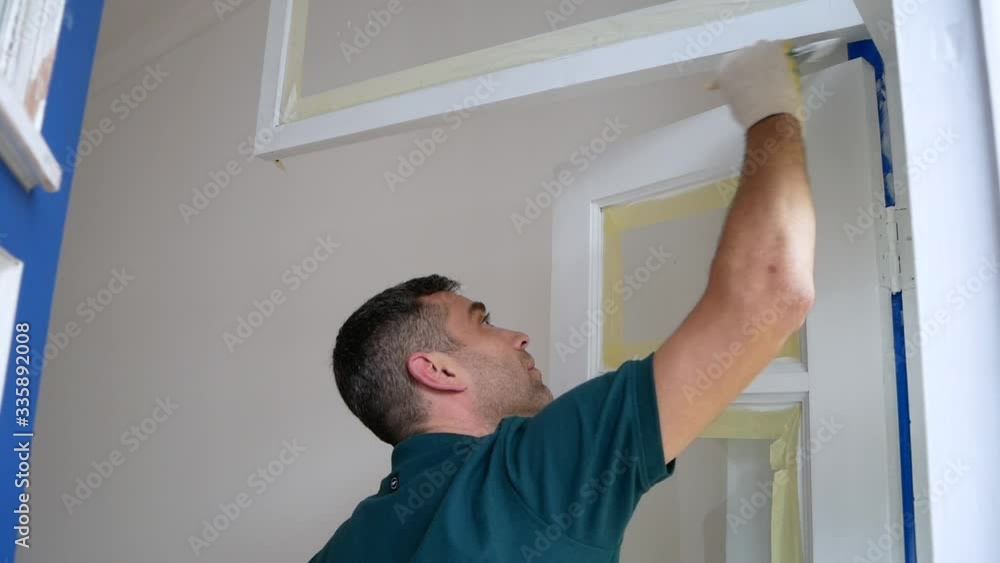 Man painting door or window with brush. Repairing flat