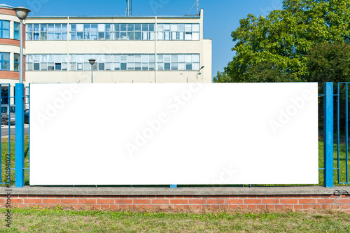 Blank white advertising banner on the fence in front of the office building photo