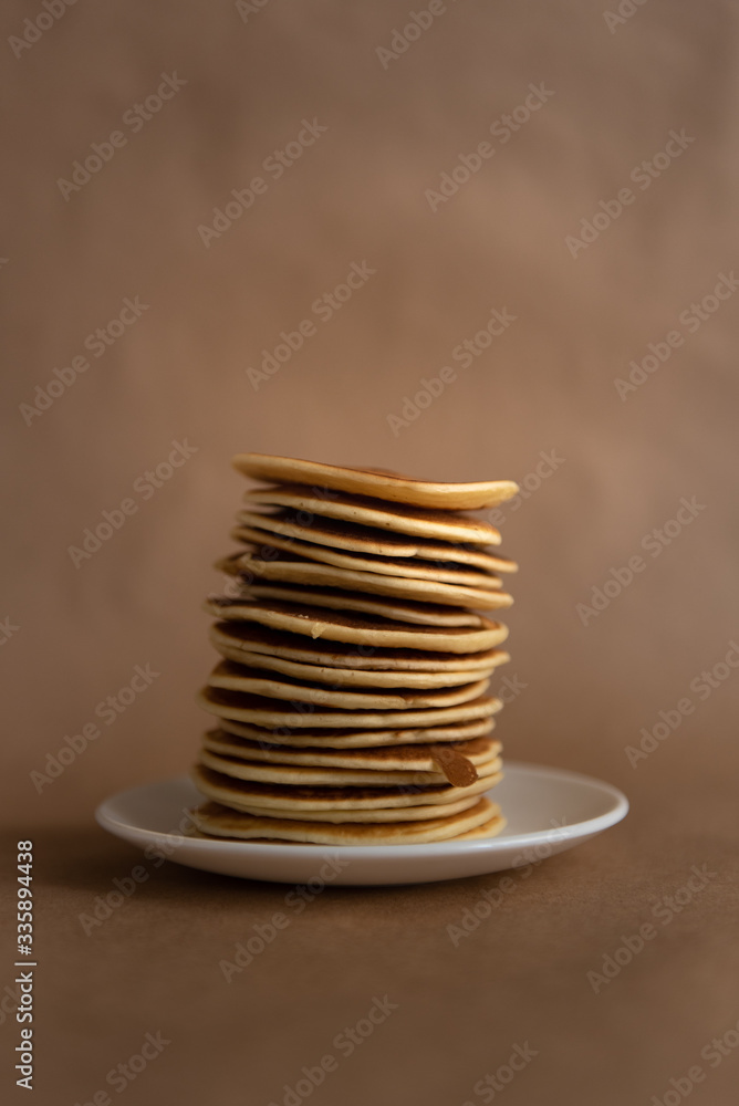 stack of pancakes on a white plate on craft background stack of pancakes on a white plate on craft background