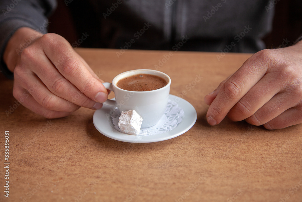 Close-up of coffee cup and hands on a table Close-up of coffee cup and hands on a table