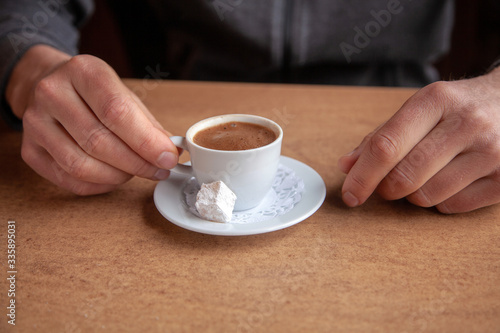 Close-up of coffee cup and hands on a table