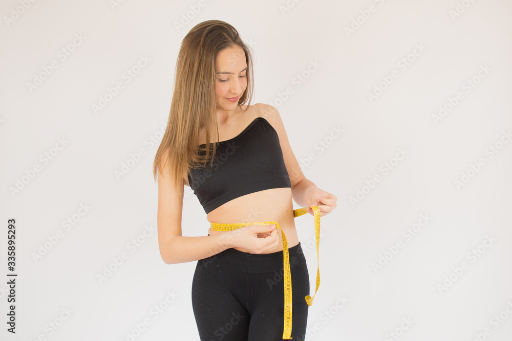 Beautiful fitness girl measuring her waist Beautiful fitness girl measuring her waist