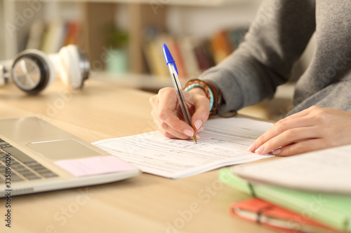 Fototapet Student hands filling out form document at home
