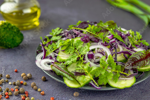 salad with vegetables and herbs on a light table, background with blurred sharpness, on a light background. Healthy food concept.