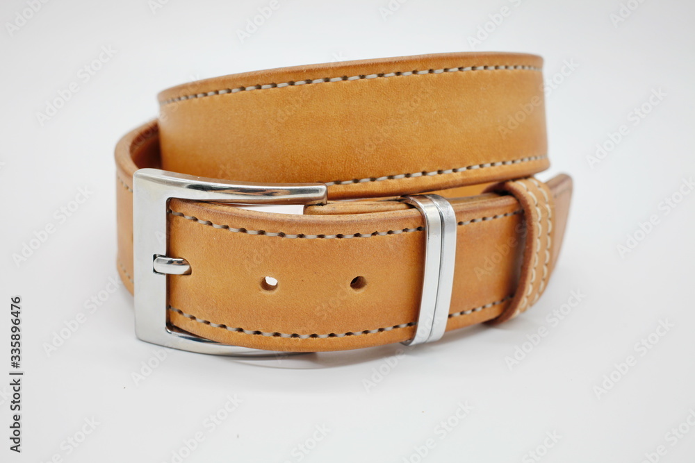 sample of brown leather men's belt with metal shiny handmade buckle, stitched on the edge, hand craft concept, white background,close up sample of brown leather men's belt with metal shiny handmade buckle, stitched on the edge, hand craft concept, white background,close up