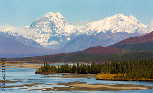 Two snow-capped mountains rise above the braided Susitna River