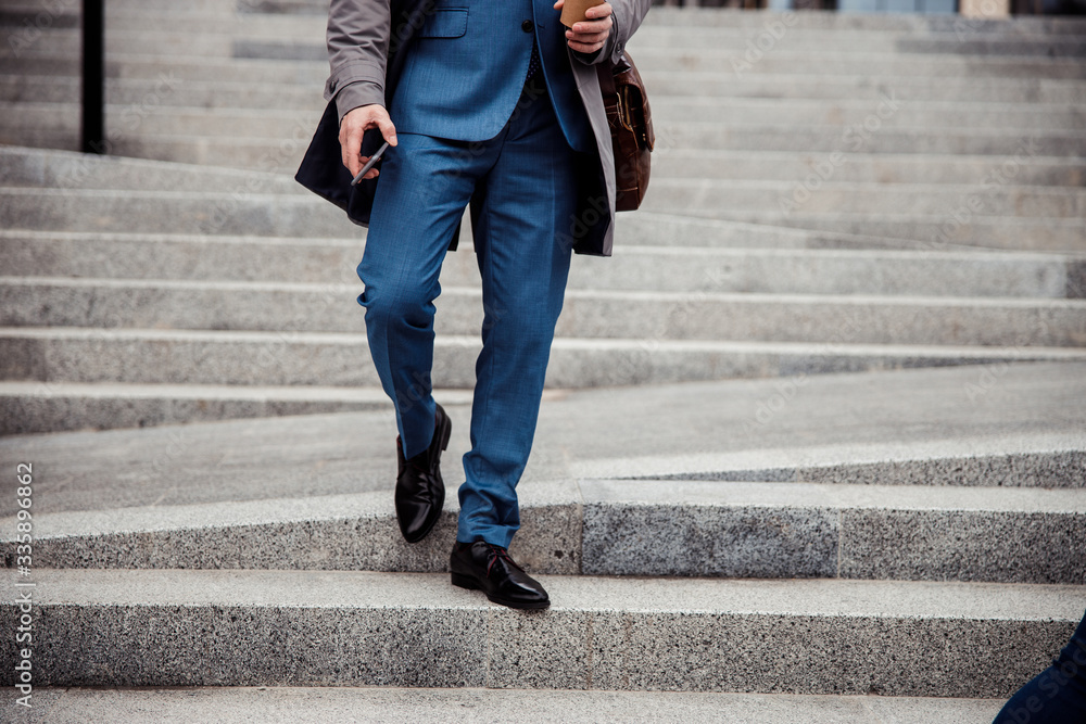 Male in stylish shoes walking down the steps