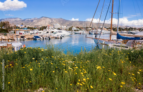Beautiful spring season in Glyfada harbor with spring flowers, moored boats, calm sea, blue sky of suburb in South Athens located in the Athens Riviera, Greece. photo