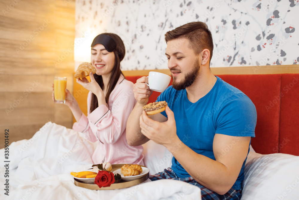 Romantic couple, breakfast in bed, caring husband Romantic couple, breakfast in bed, caring husband