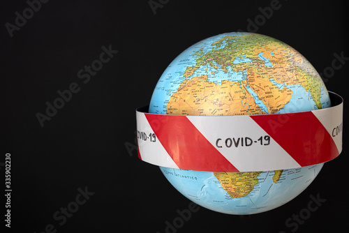 Wallpaper Mural Planet earth with caution barrier tapes. Fight and prevention against coronavirus. Global quarantine concept. In the foreground Europe, Africa, Asia. Black background Torontodigital.ca