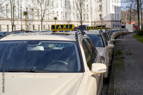 Fotografering Berlin Germany, Line of yellow taxi cabs parking in a street in inner city of berlin