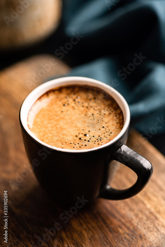 Cup of black espresso coffee on wooden table background. Closeup view. Aromatic coffee cup