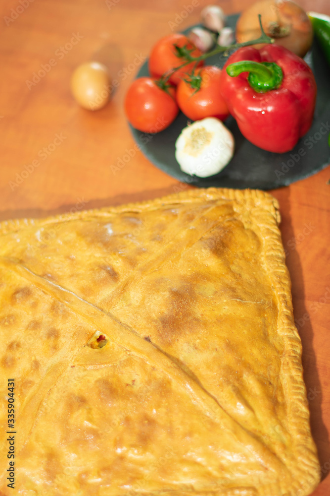 Galician empanada surrounded by other products on the table Galician empanada surrounded by other products on the table