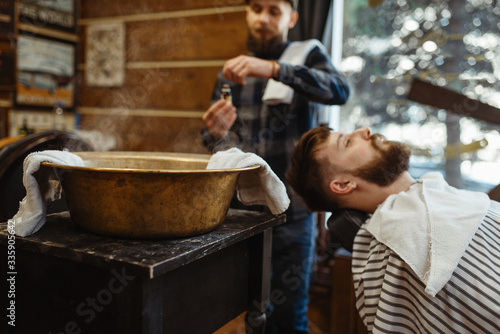 Barber soaks the towel  beard cutting  barbershop