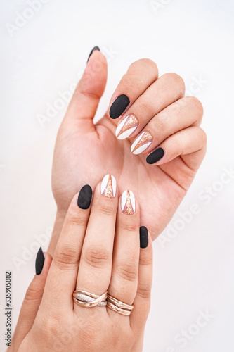 Hands of a girl with a beautiful combined manicure on display. Polish on hands.
