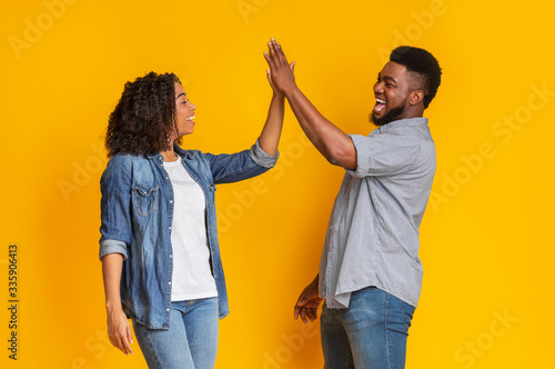 Common Success. Happy african american couple giving high-five, greetng each other photo