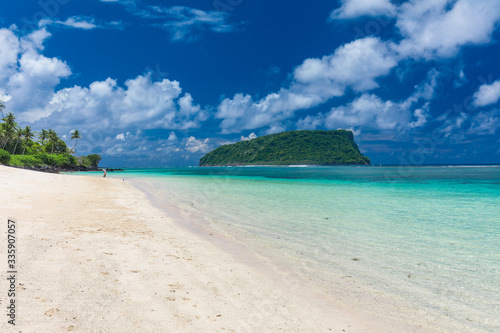 Tropical beach on south side of Samoa Island with coconut palm trees