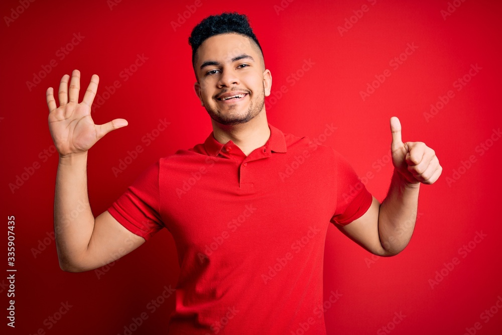 Young handsome man wearing red casual polo standing over isolated background showing and pointing up with fingers number six while smiling confident and happy. Young handsome man wearing red casual polo standing over isolated background showing and pointing up with fingers number six while smiling confident and happy.