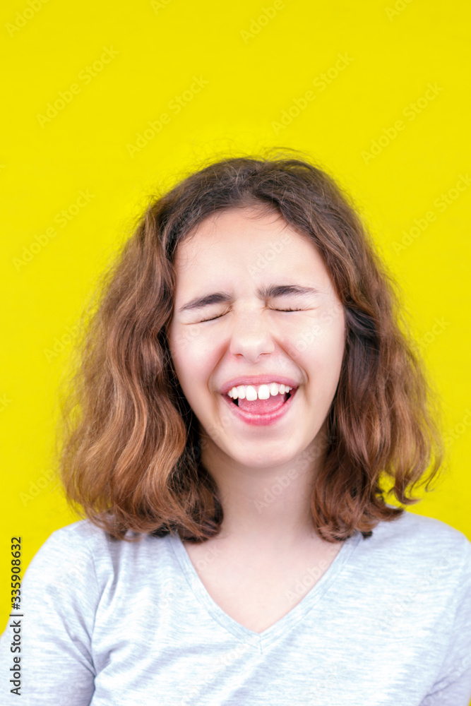 Cute curly teenager girl with funny face and closed eyes Cute curly teenager girl with funny face and closed eyes