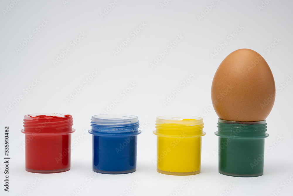 chicken eggs in colored cups on a white background chicken eggs in colored cups on a white background