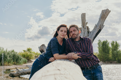 Heterosexual age difference couple  in love relax on river beach photo