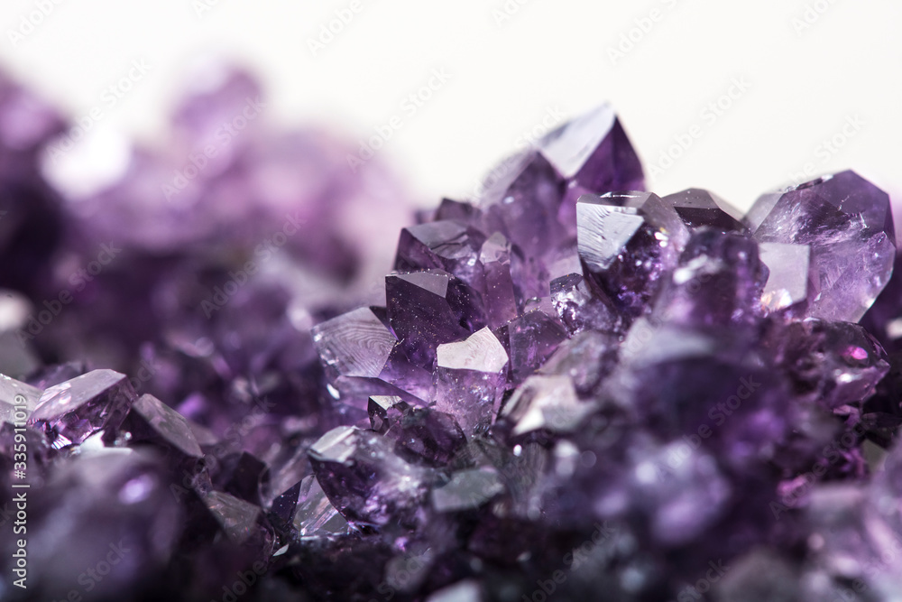 Amethyst purple crystals on white background selective focus Amethyst purple crystals on white background selective focus