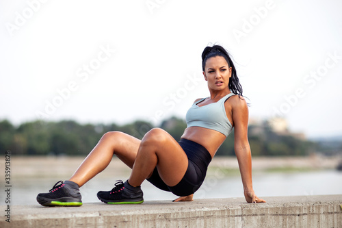 Young woman with strong body exercise outdoor after jogging