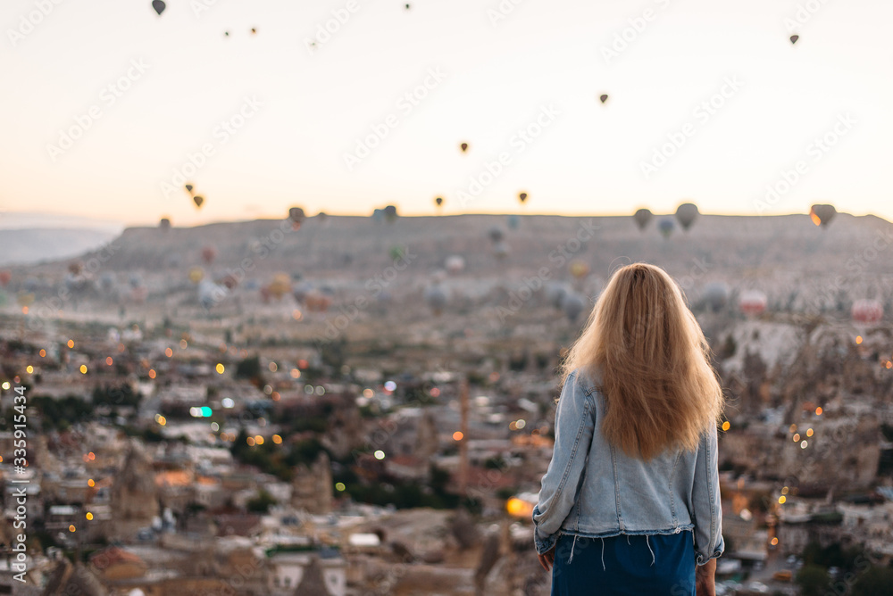 Young woman watching the sunrise in Cappadocia Young woman watching the sunrise in Cappadocia