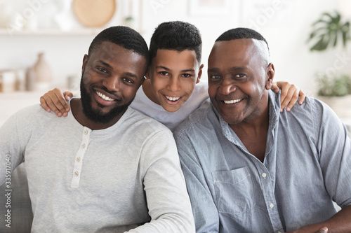 Happy black son, father and grandfather posing for family picture together