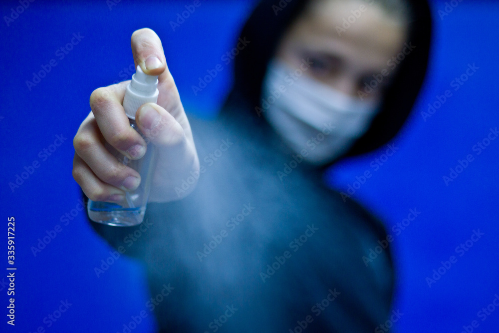 The guy in the mask with a black shirt uses hand shampoo to cleanse the hand and prevent the spread of bacteria and viruses. Concept of personal hygiene. The guy in the mask with a black shirt uses hand shampoo to cleanse the hand and prevent the spread of bacteria and viruses. Concept of personal hygiene.
