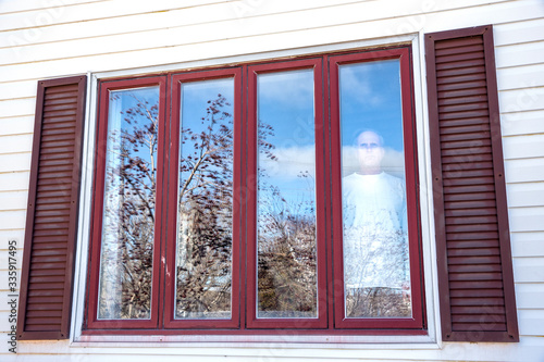 Man in isolation looking out of a window
