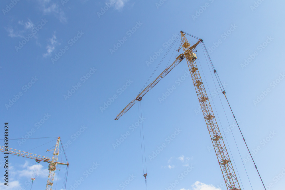 Tower crane at a construction site. Lifting heavy loads Tower crane at a construction site. Lifting heavy loads