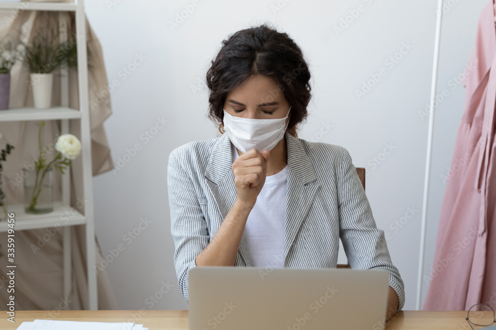 Young businesswoman employee wearing protective facemask coughing, feeling unwell at office. Unhealthy infected worker suffering from virus symptoms, need medical treatment hospitalization quarantine. Young businesswoman employee wearing protective facemask coughing, feeling unwell at office. Unhealthy infected worker suffering from virus symptoms, need medical treatment hospitalization quarantine.