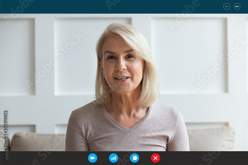Foto Head shot aged woman qualified psychologist looks at cam during psychological support session on-line counselling with client over telecommunication app