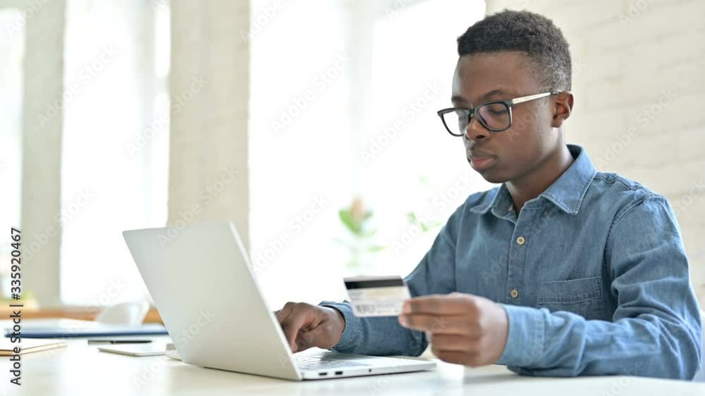 Successful Online Payment by Young African Man on Laptop Successful Online Payment by Young African Man on Laptop