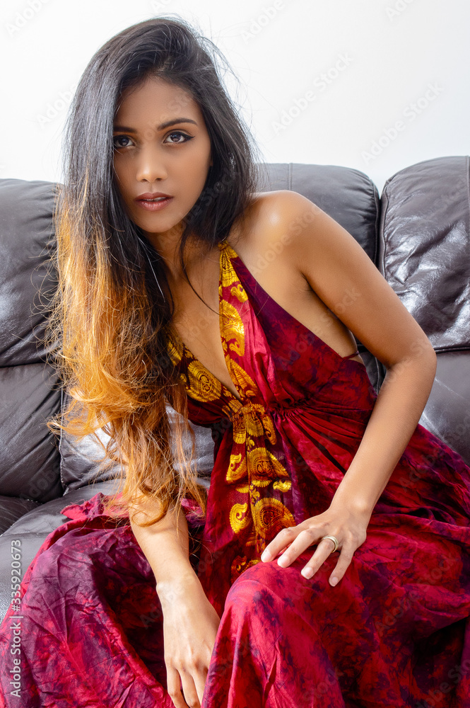 Obraz premium Portrait of a young woman with long hair sitting on the couch.