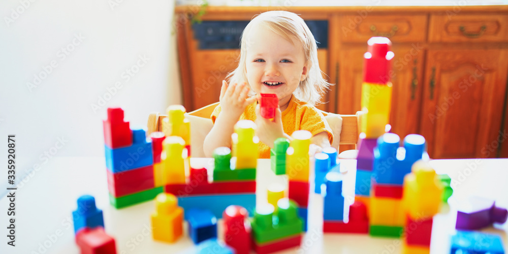 Little girl playing with colorful plastic construction blocks Little girl playing with colorful plastic construction blocks
