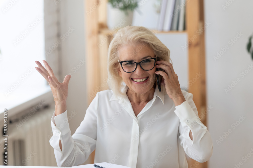 Happy smiling 60 years old businesswoman talking on phone, making business call close up. Employee chatting with friend during break, manager consulting client customer by cellphone. Happy smiling 60 years old businesswoman talking on phone, making business call close up. Employee chatting with friend during break, manager consulting client customer by cellphone.