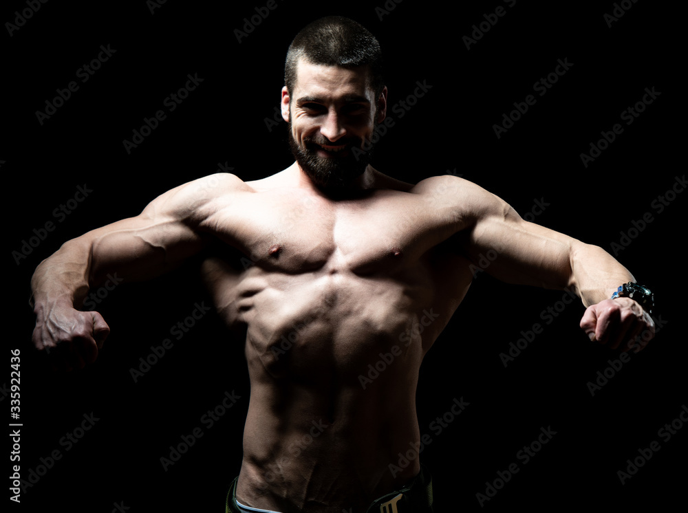 Young Bodybuilder Flexing Muscles Isolate on Black Blackground