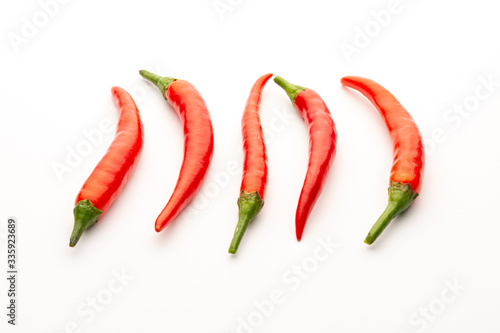 Red chili peppers on a white background. Isolate. Hot peppers. A few fresh pods of red pepper.