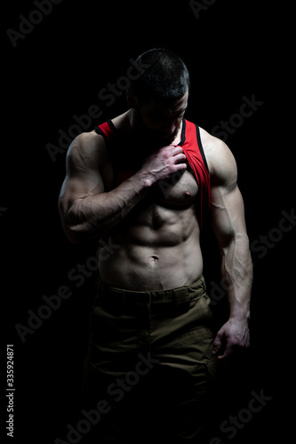 Muscular Man Flexing Muscles on Black Background