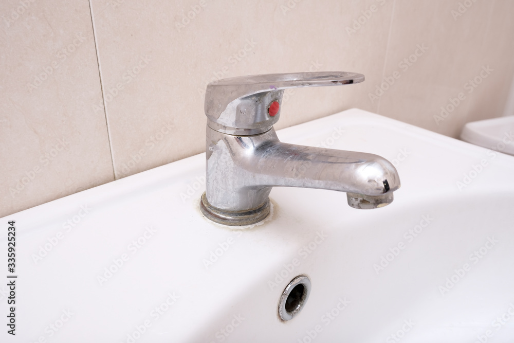 Dirty faucet with limescale, calcified water tap with lime scale on washbowl in bathroom, home cleaning concept Dirty faucet with limescale, calcified water tap with lime scale on washbowl in bathroom, home cleaning concept