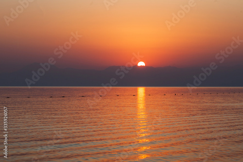 Red sunset at sea over the mountains. Turkey. Horizontal photo.