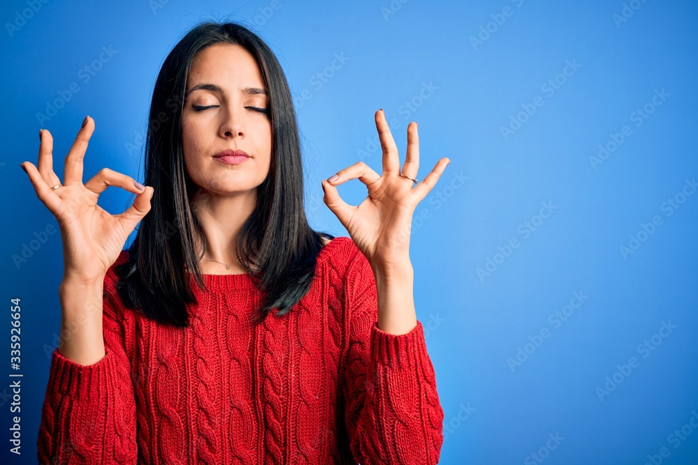 Young brunette woman with blue eyes wearing red casual sweater over isolated background relax and smiling with eyes closed doing meditation gesture with fingers. Yoga concept. Young brunette woman with blue eyes wearing red casual sweater over isolated background relax and smiling with eyes closed doing meditation gesture with fingers. Yoga concept.