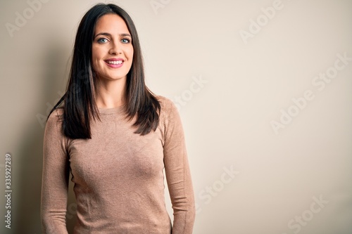 Photography Young brunette woman with blue eyes wearing casual sweater over isolated white background with a happy and cool smile on face