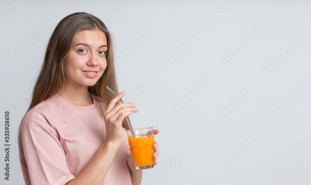 Young cheerful girl drinking orange juice with straw Young cheerful girl drinking orange juice with straw
