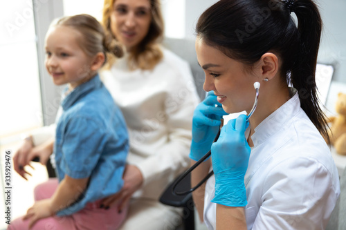 Young female doctor using stethoscope in hospital