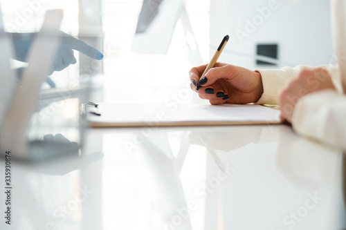 Cropped photo of Caucasian mother writing permission on treatment