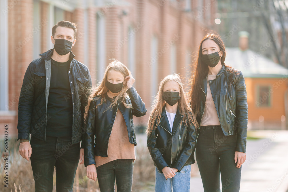 Family wearing a mask on a background of a modern building,